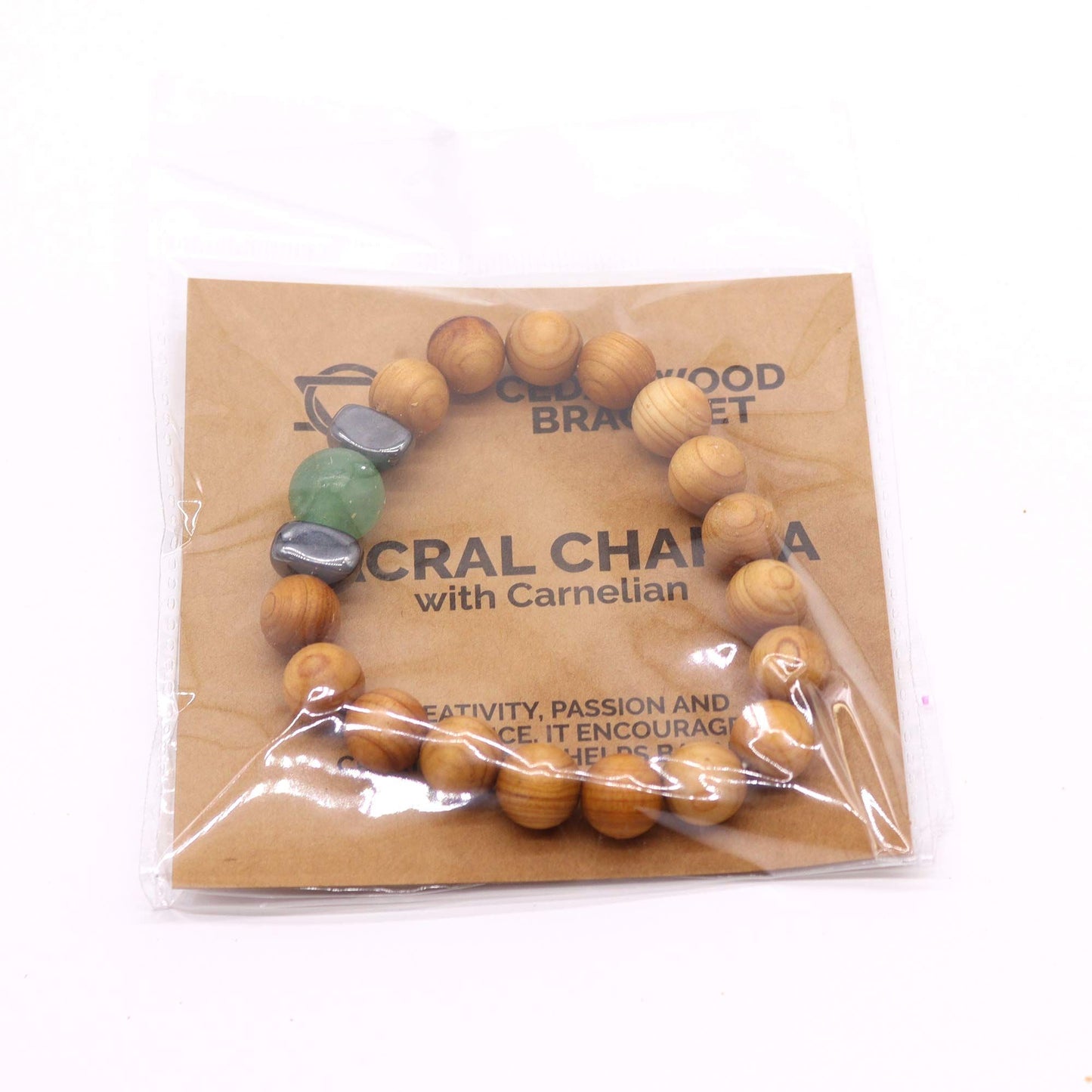 Detailweergave van cederhouten sacraal chakra-armband met natuurlijke houten kralen en groene aventurijn voor creatieve energie