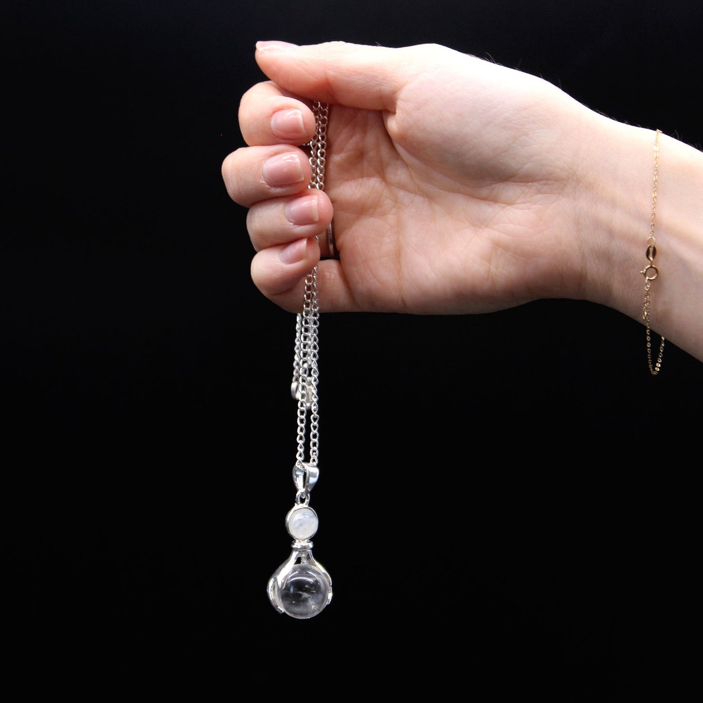 Detailweergave van de Healing Hands-hanger met gepolijste kwartskristallen bol en verzilverd vakmanschap voor innerlijke harmonie