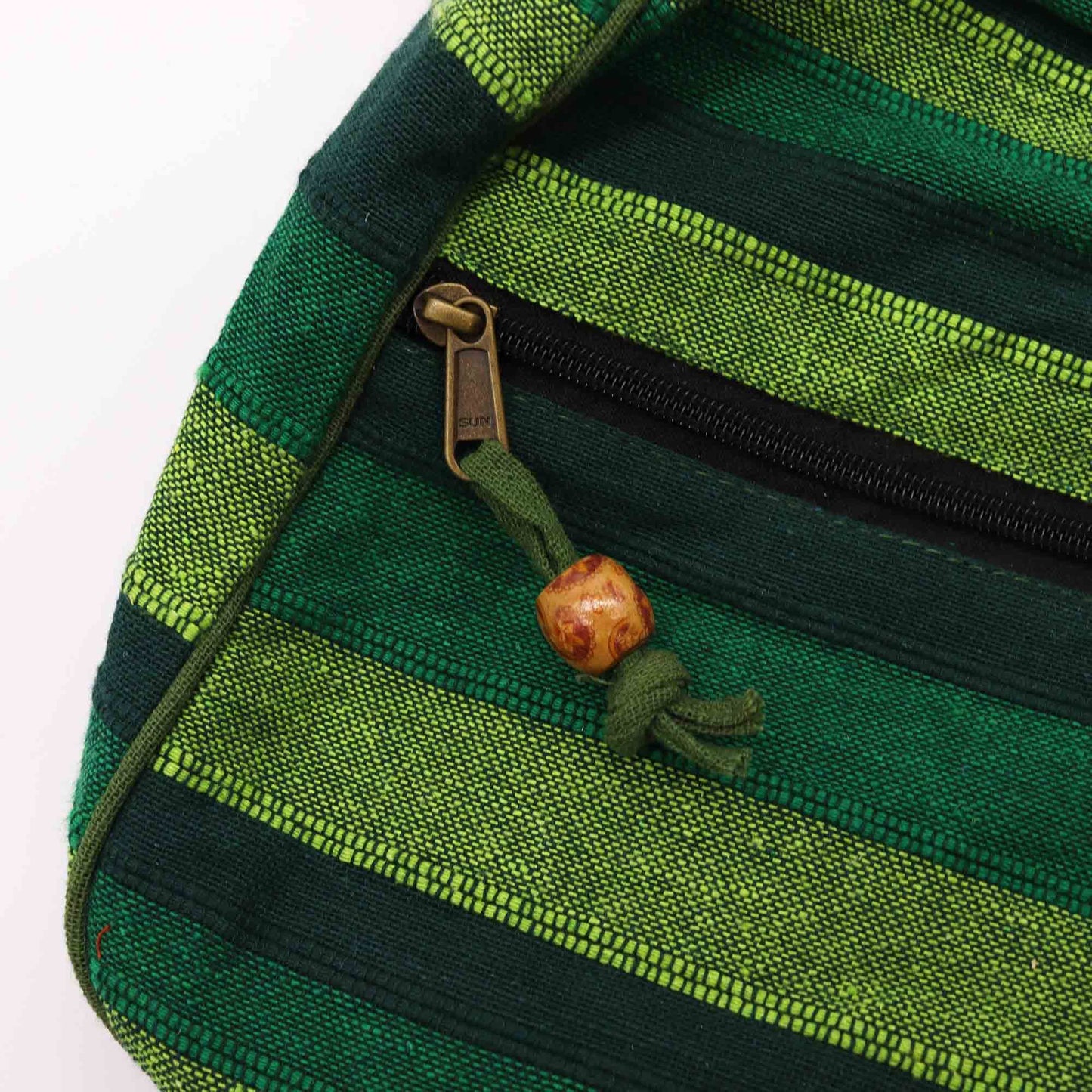 Close-up detail van bosgroen gestreept weefwerk en traditioneel Nepalees vakmanschap op crossbodytas