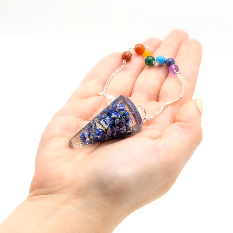 Orgoniet chakra pendel met lapis lazuli in de hand, energie healing en wijsheid tool