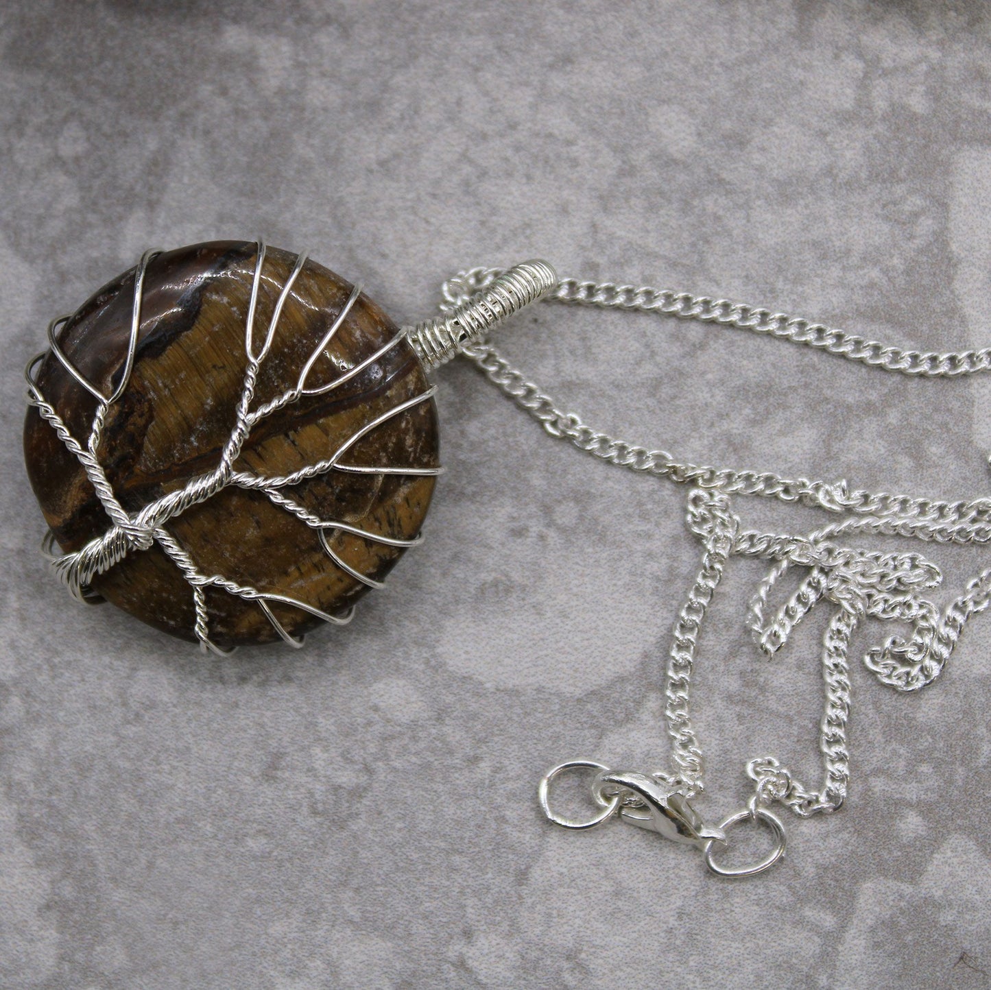Tree of Life edelstenen ketting gedragen met tijgeroog hanger en verzilverd vakmanschap voor beschermende aardende energie