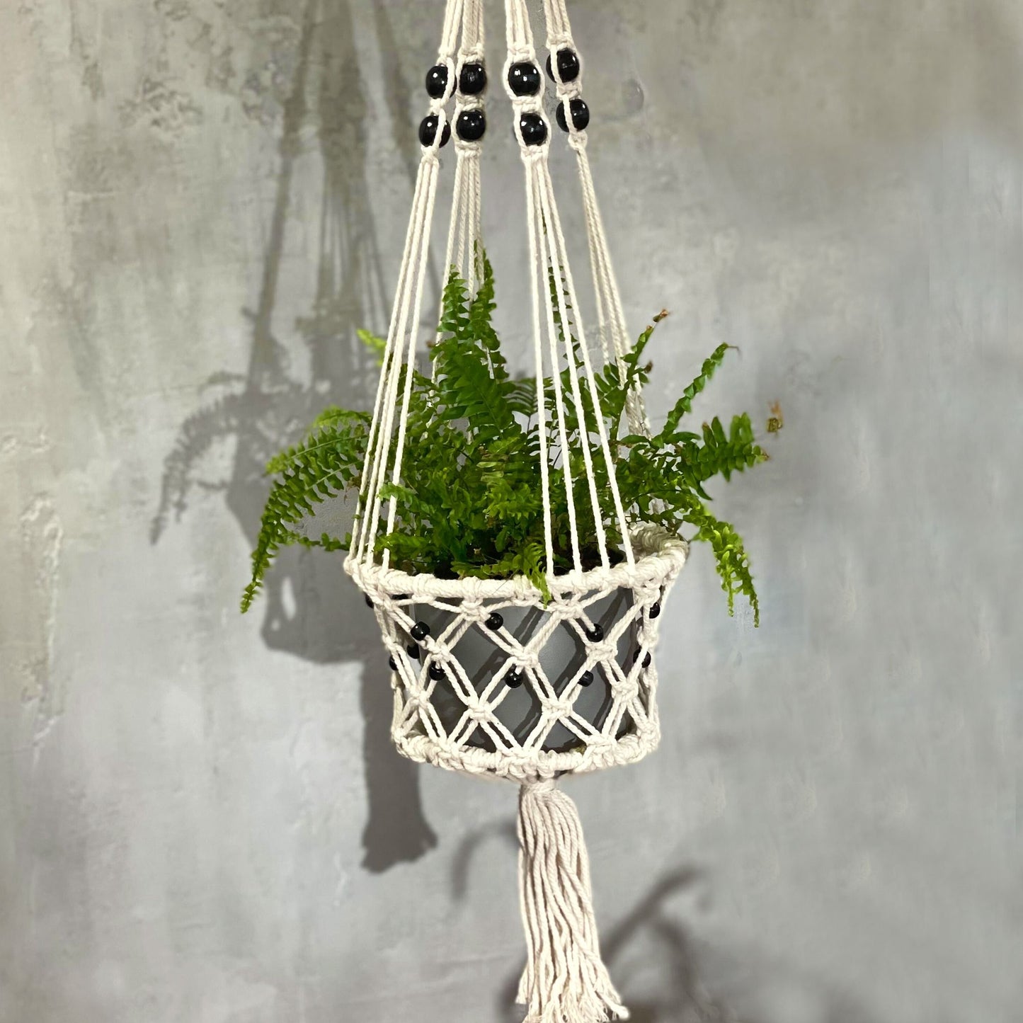Macramé plantenhanger groot met hangplant en kralenaccent - bohemian plantaccessoire