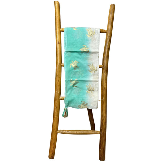 Close-up detail van handbeschilderd turquoise en goud schildpadpatroon op witte sari katoen pario