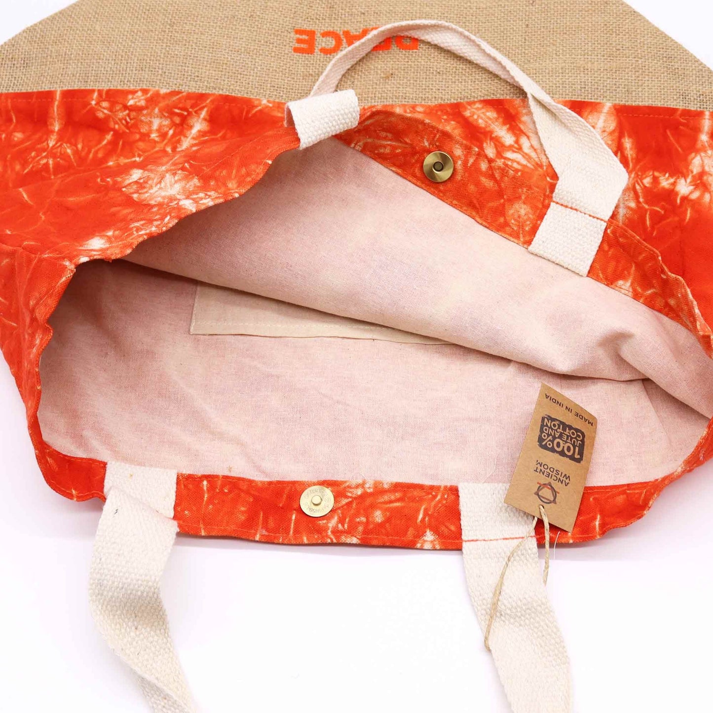 Close-up detail van Namaste-handsymbool op handgeweven katoenen draagtas in warm oranje