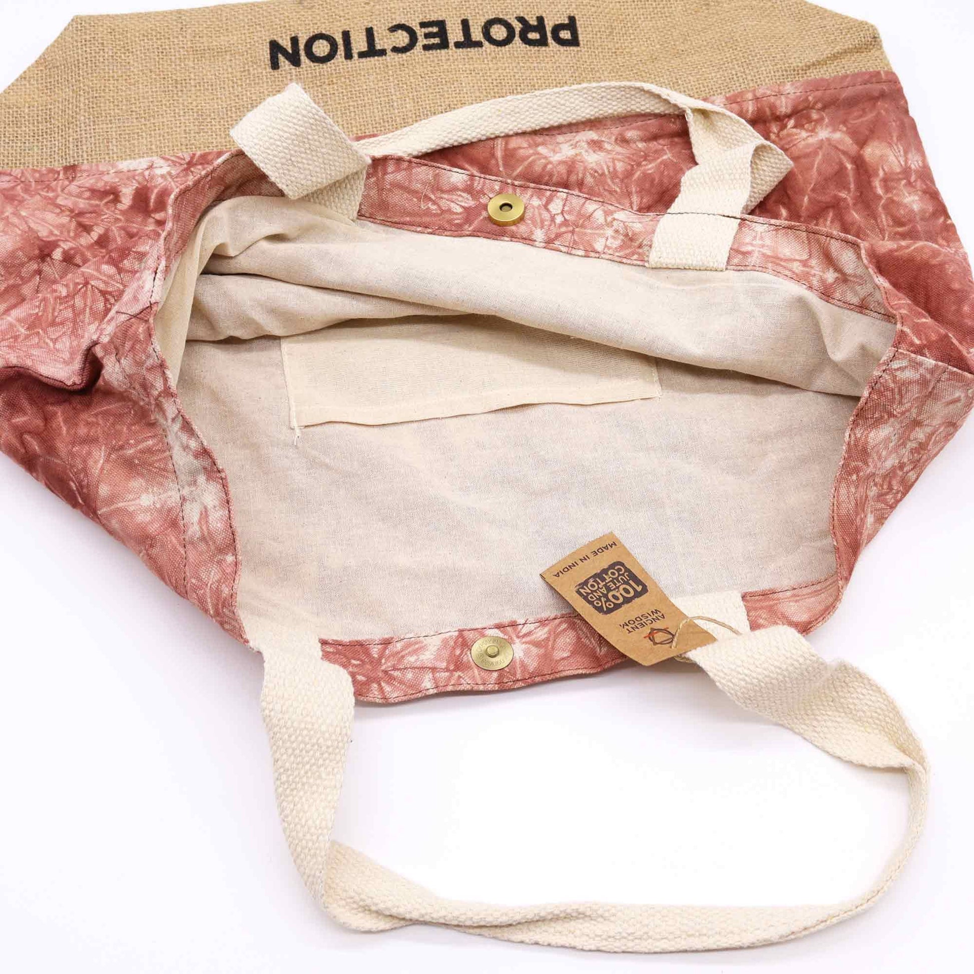 Close-up detail van beschermend Hamsa-symbool op handgeweven katoenen draagtas in rijke terracotta