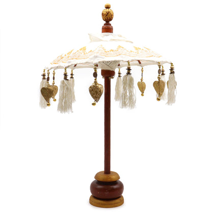 Handgemaakte Balinese parasol voor in huis met wit canvas en gedetailleerde gouden versieringen, traditioneel Indonesisch decoratief accent uit Bali met een diameter van 40 cm.
