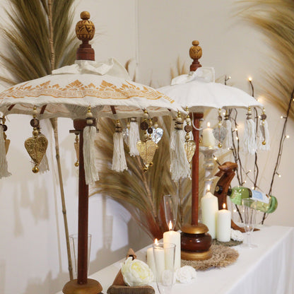 Close-up van decoratieve parasol uit Bali met gouden ornamenten op wit canvas, handgemaakt Balinees vakmanschap
