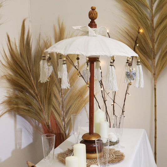 Close-up van decoratieve parasol uit Bali met natuurlijke canvasstructuur en hangende kwastjes, handgemaakt Balinees vakmanschap
