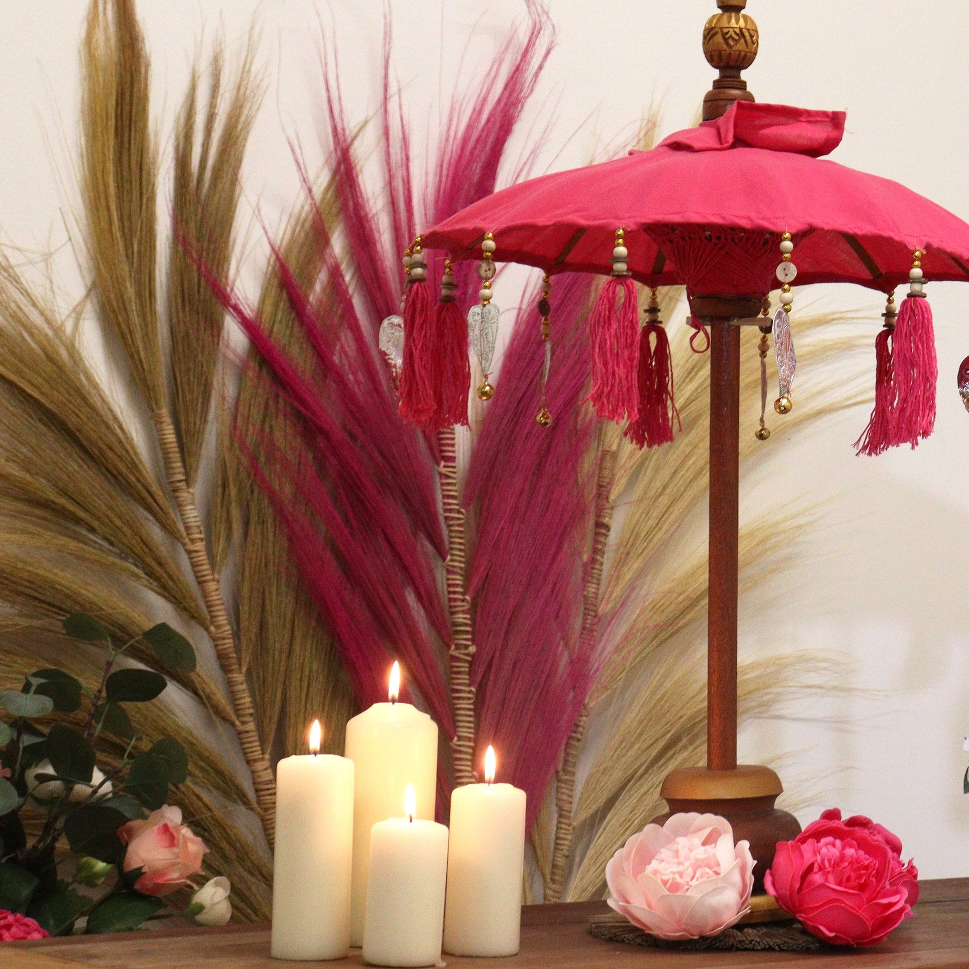 Lifestylefoto van roze Balinese parasol in interieur, speelse bohemien decoratieve accent met authentiek Indonesisch vakmanschap
