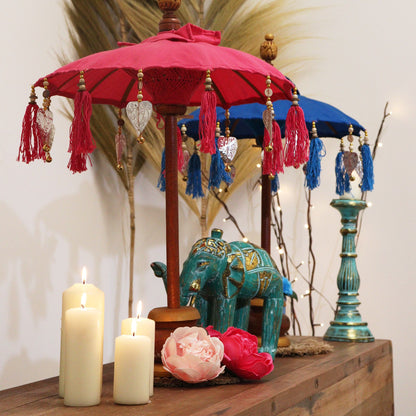 Lifestylefoto van een turquoise parasol uit Bali in een interieur, verfrissend bohemien decoratief accent met authentiek Indonesisch vakmanschap.
