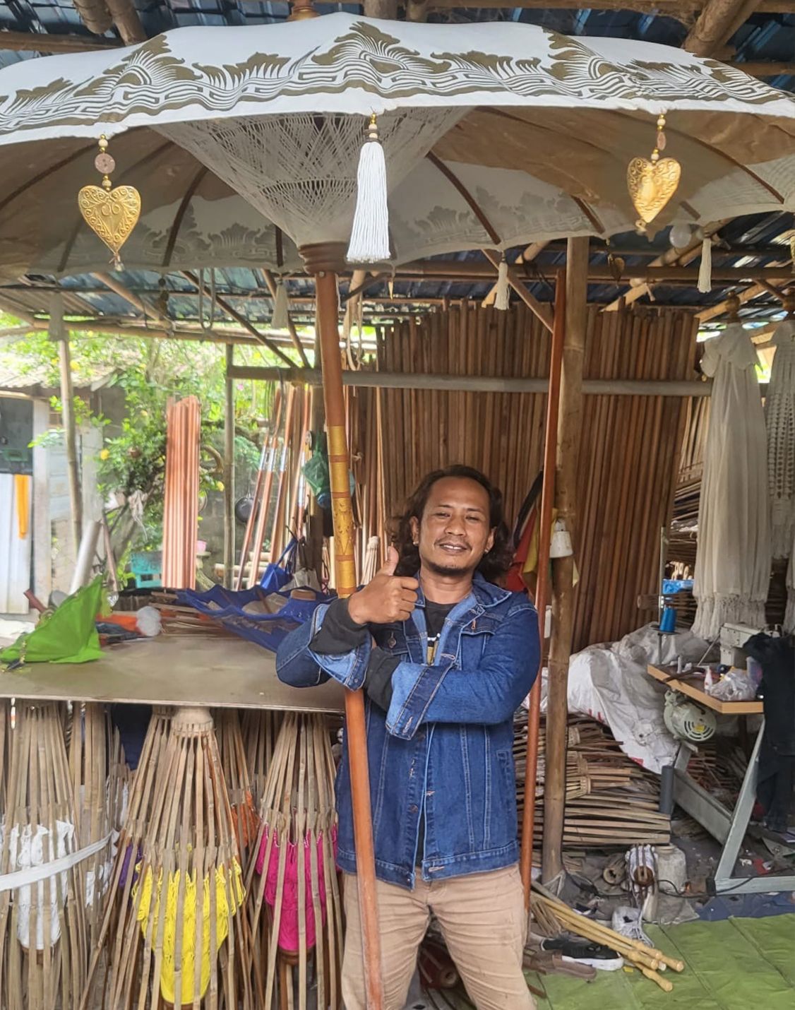 Bovenaanzicht van grote Bali-terrasparasol met natuurlijk canvas en kwastjes, traditionele Indonesische tuinparasol
