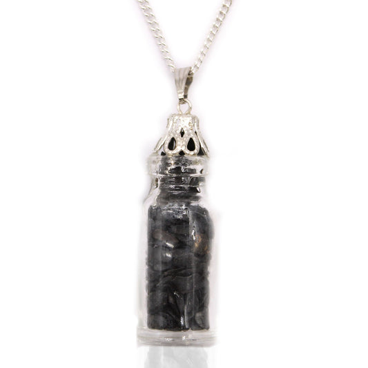 Zwarte onyx edelstenen ketting met echte kristallen stukjes verzegeld in een glazen flesje aan een verzilverde ketting