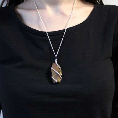 Cascade Wrapped Gemstone Necklace gedragen op zwarte kleding, ruwe Rough Tiger Eye hanger met zilverkleurige wire-wrapping, lifestyle foto
