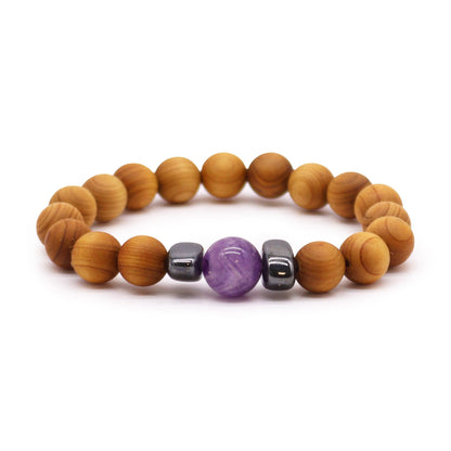 Cederhouten derde oog chakra armband met natuurlijke houten kralen en paarse amethistkristallen op een witte achtergrond, spirituele sieraden voor het derde oog chakra, intuïtie en spiritueel bewustzijn.

