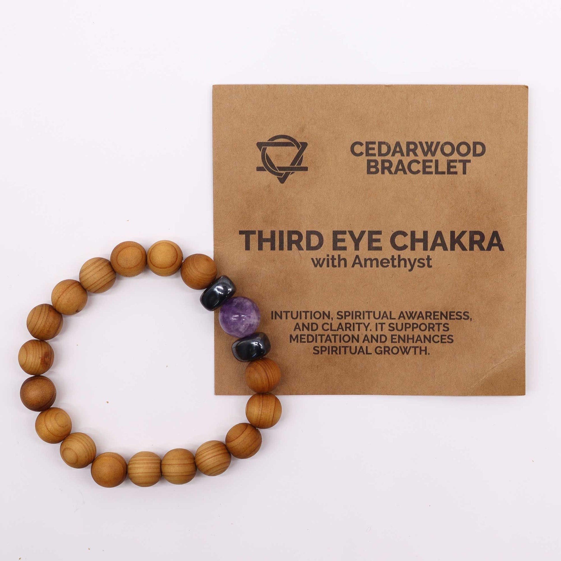 Close-up van cederhouten derde oog chakra armband met natuurlijke houten kralen en paarse amethist edelsteen
