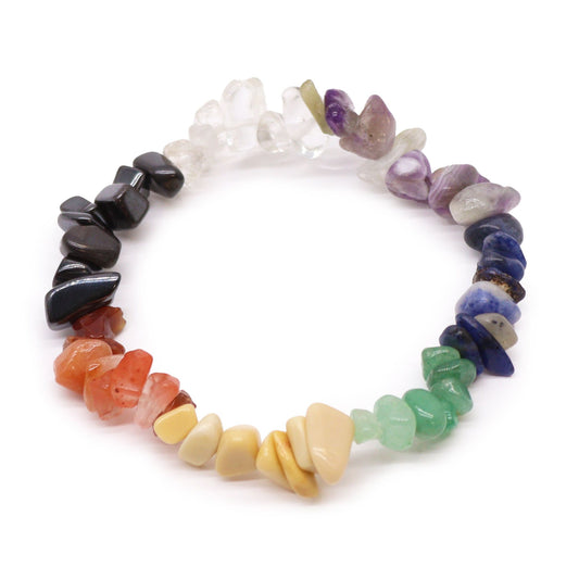 Chakra-stenen chipstone-armband met zeven natuurlijke regenboogkristallen op een witte achtergrond, handgemaakte stretch-sieraden voor energiebalans en chakra-uitlijning