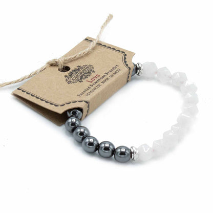 Facettenarmband van rozenkwarts met magnetische sluiting en gepolijste roze edelsteen kralen op een witte achtergrond, handgemaakte sieraden voor liefde en healing van het hartchakra.

