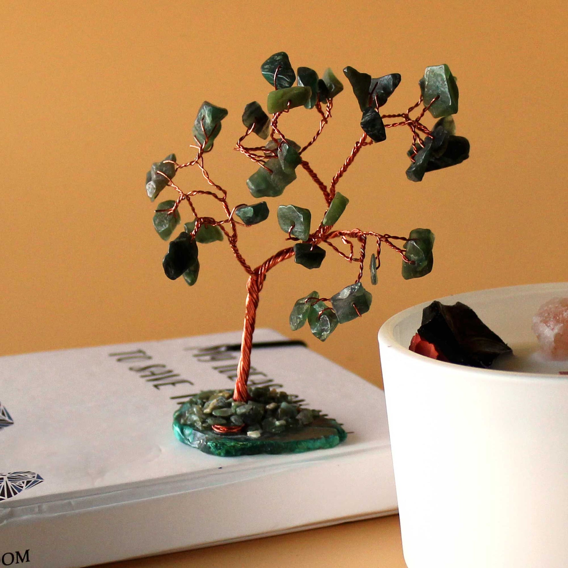 Close-up van groene aventurijn edelsteen wensboom op natuurlijke groene agaat basis met draadgewikkelde stenen, handgemaakt decoratiestuk voor overvloed