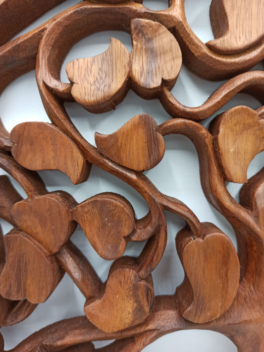 Close-up van ingewikkelde, met de hand gesneden hartjes op een houten paneel met de Tree of Life
