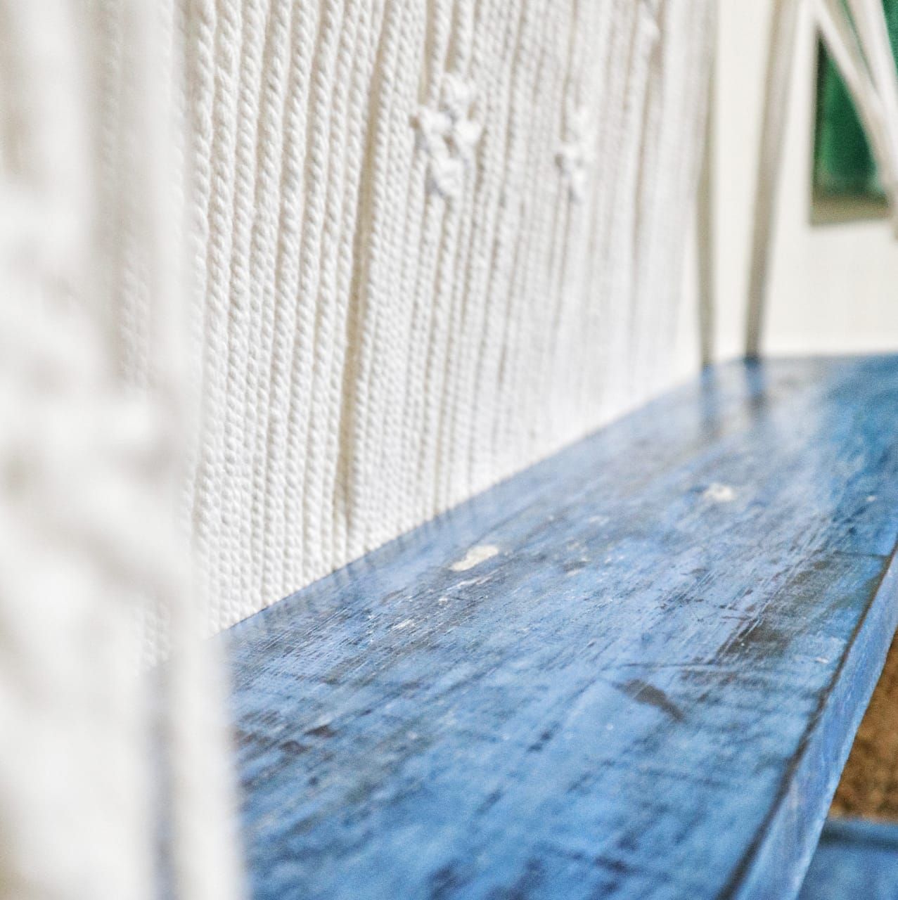 Macramé hangplank gestyled met planten en decoraties, natuurlijk blauw bohemien interieur
