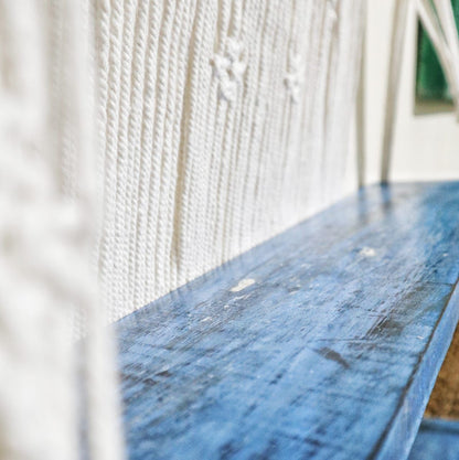 Macramé hangplank gestyled met planten en decoraties, natuurlijk blauw bohemien interieur
