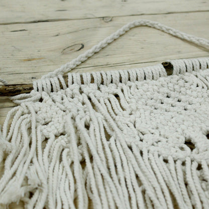 Macramé wandkleed met hartmotief aan de muur, boho minimalistische decoratie
