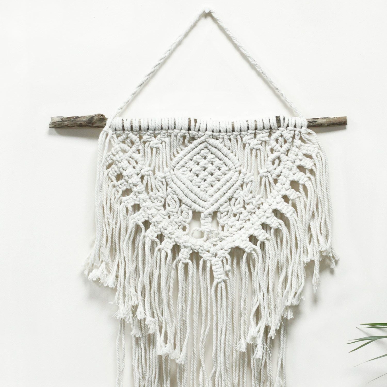 Natuurlijke katoenen macramé wanddecoratie met tribaal geïnspireerd hartmotief voor boho-interieurs
