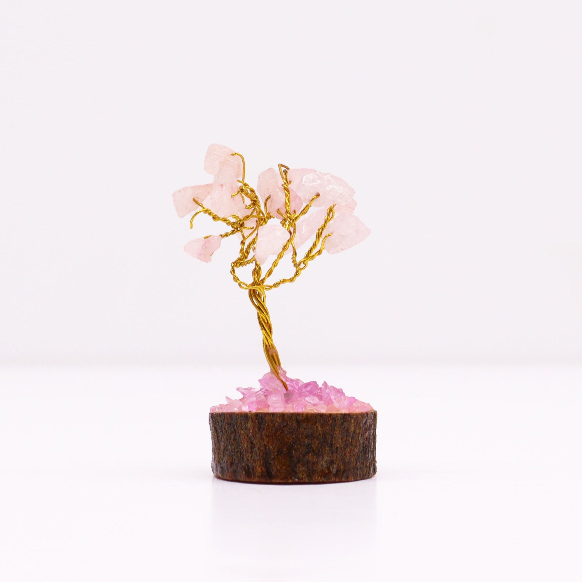 Detailfoto van mini-rozenkwarts edelsteenboom met roze kristallen stukjes en natuurlijke houten voet, handgemaakt meditatief object in zakformaat.
