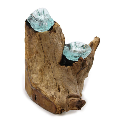 Lifestylefoto van een dubbele kandelaar van gesmolten glas met brandende kaarsen, warme sfeerverlichting op een natuurlijke houten voet, gezellige milieuvriendelijke decoratie
