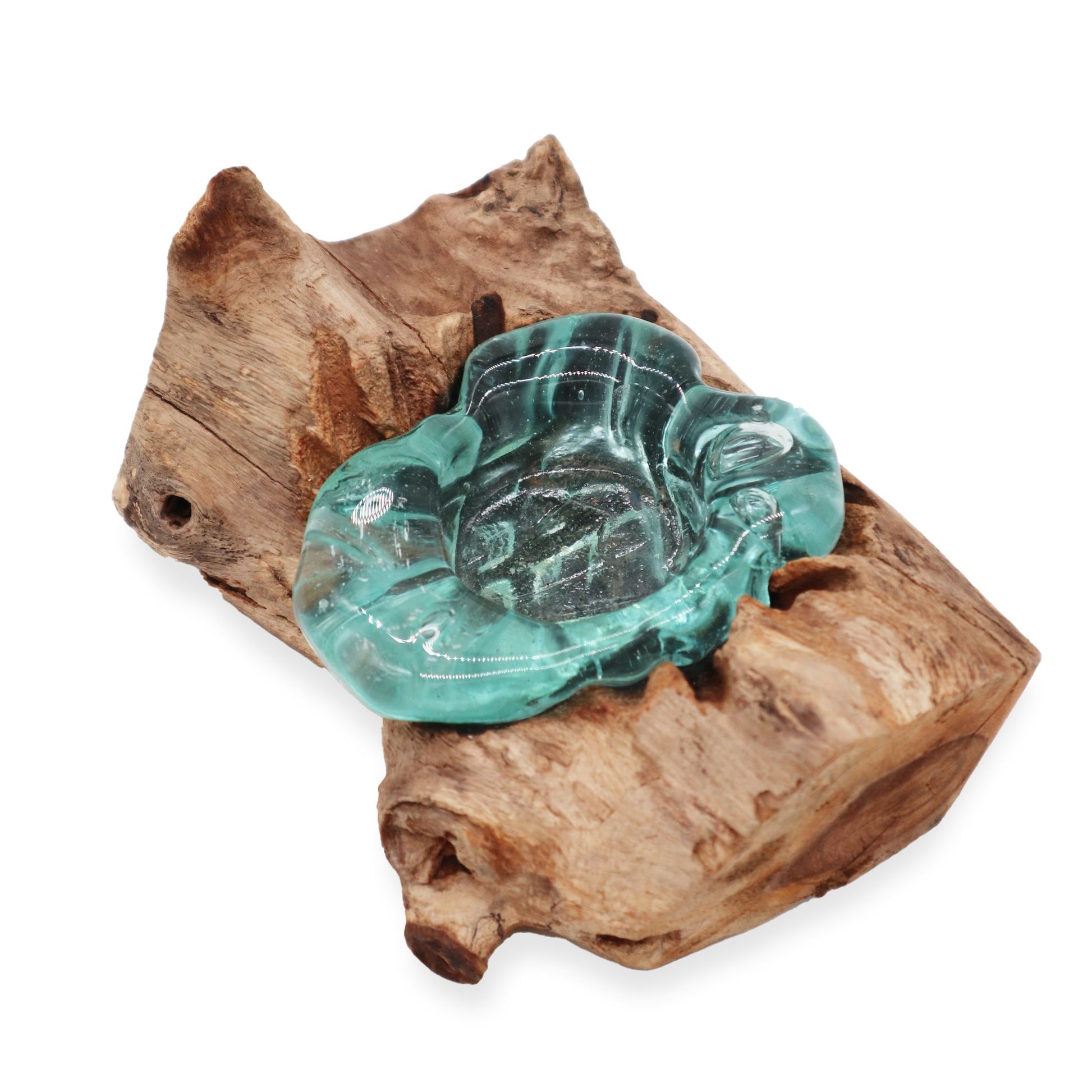 Close-up van een kandelaar van gesmolten glas, gemaakt van handgeblazen gerecycled glas dat is versmolten met natuurlijk hout, met traditionele Balinese details.
