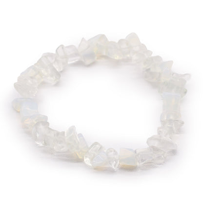 Opaliet chipstone armband met lichtgevende melkwitte kristallen die blauwe irisatie vertonen op een witte achtergrond, handgemaakte stretch sieraden voor sereniteit en balans van het derde oog chakra.
