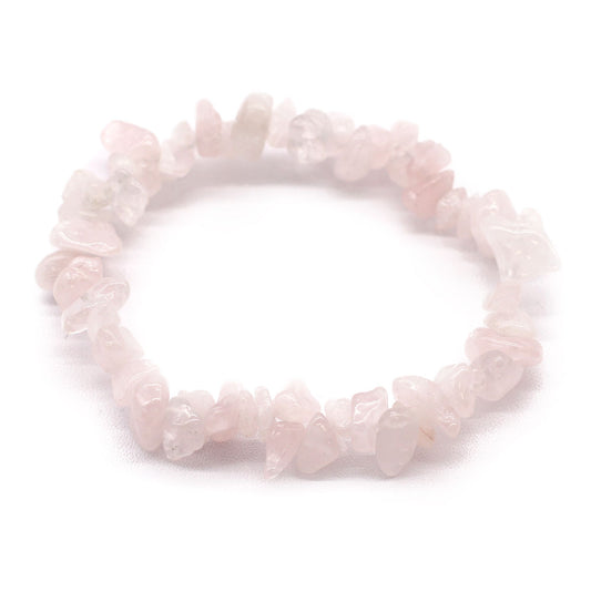 Rozenkwarts chipstone armband met natuurlijke zachtroze kristallen op een witte achtergrond, handgemaakte stretch sieraden voor liefde en balans in het hartchakra.
