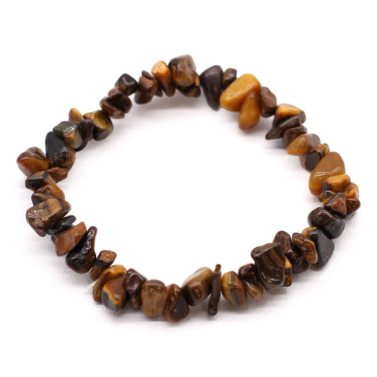 Tijgeroog chipstone armband met natuurlijke goudbruine kristallen die een chatoyante glans vertonen op een witte achtergrond, handgemaakte stretch sieraden voor moed en balans in het zonnevlechtchakra.
