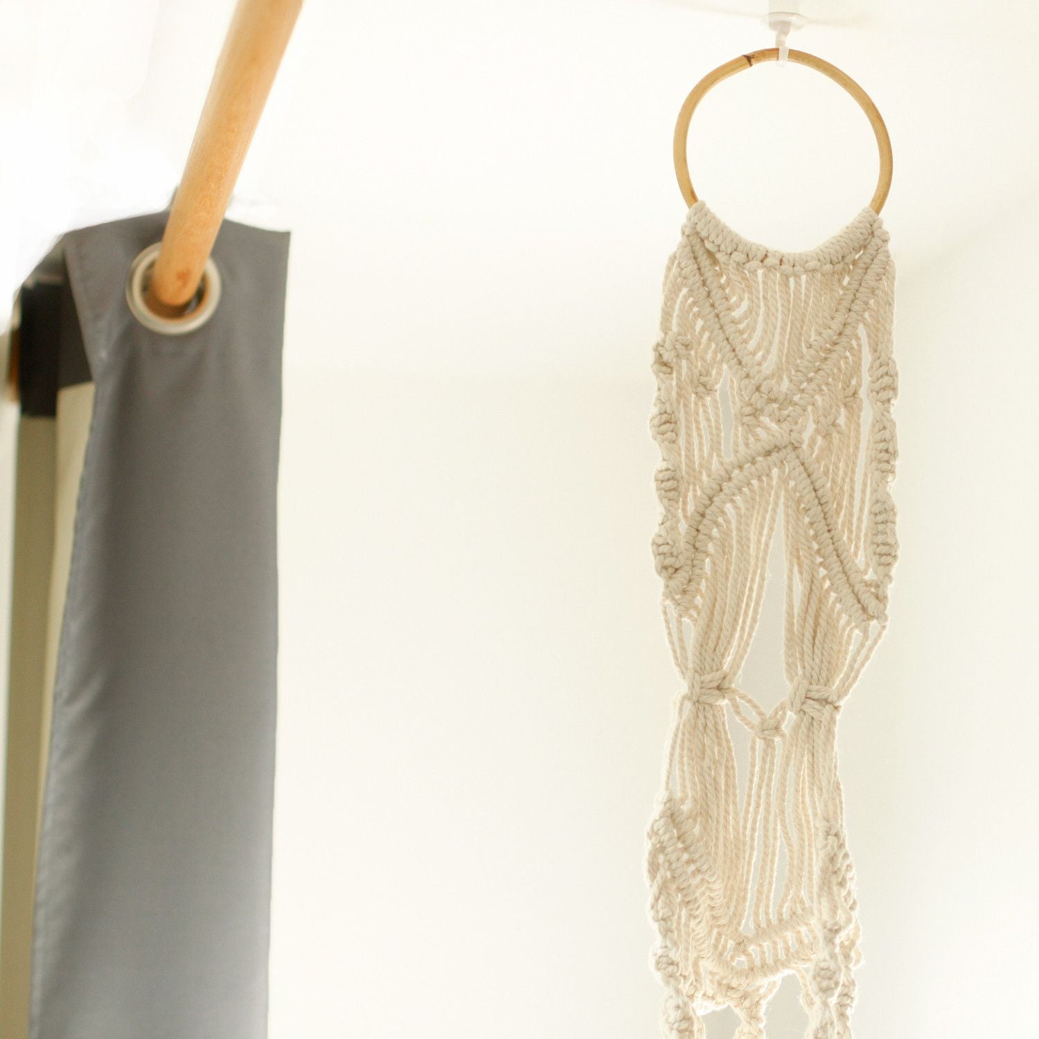 Close-up van macramé plantenhouder met decoratieve rotan ring en traditionele knooptechnieken
