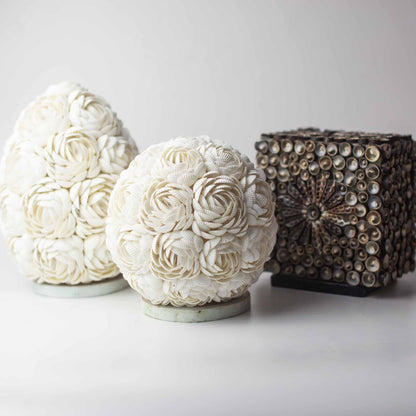 Close-up van roze schelpen lamp met natuurlijke schelpen en warm licht, handgemaakt
