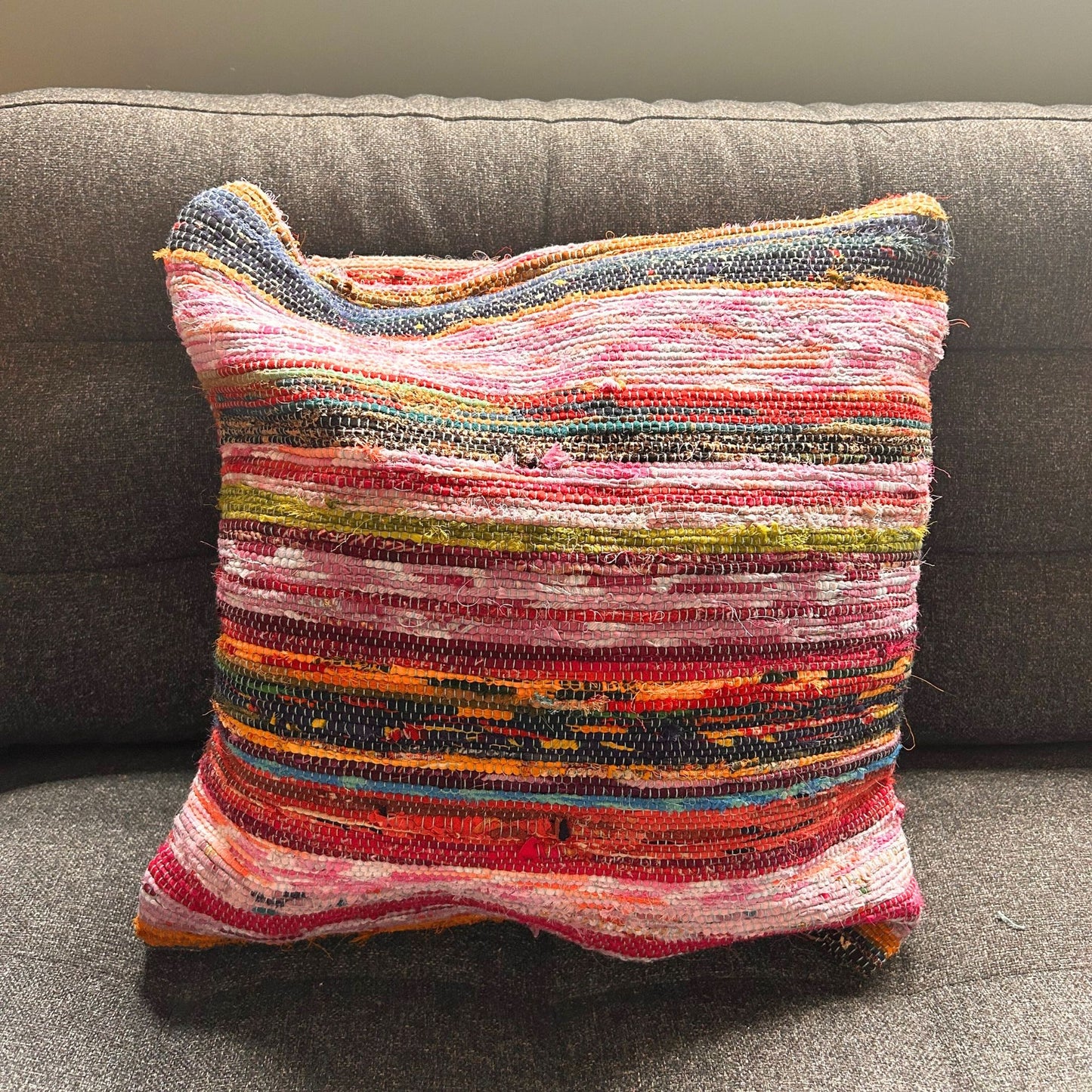 Close-up detail van gerecyclede tapijt kussenhoes met kleurrijke stroken in aqua, turquoise en blauwgroen, traditionele Indiase weeftechniek
