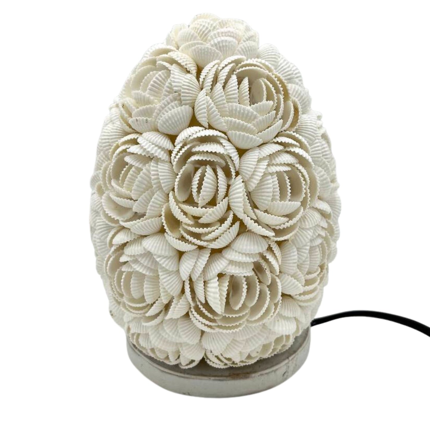 Detail van handgemaakte schelpen lamp met ovaal patroon en romantische gloed
