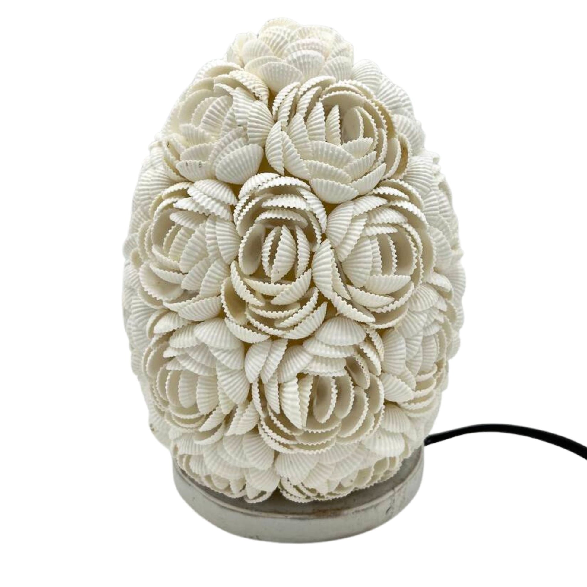 Detail van handgemaakte schelpen lamp met ovaal patroon en romantische gloed
