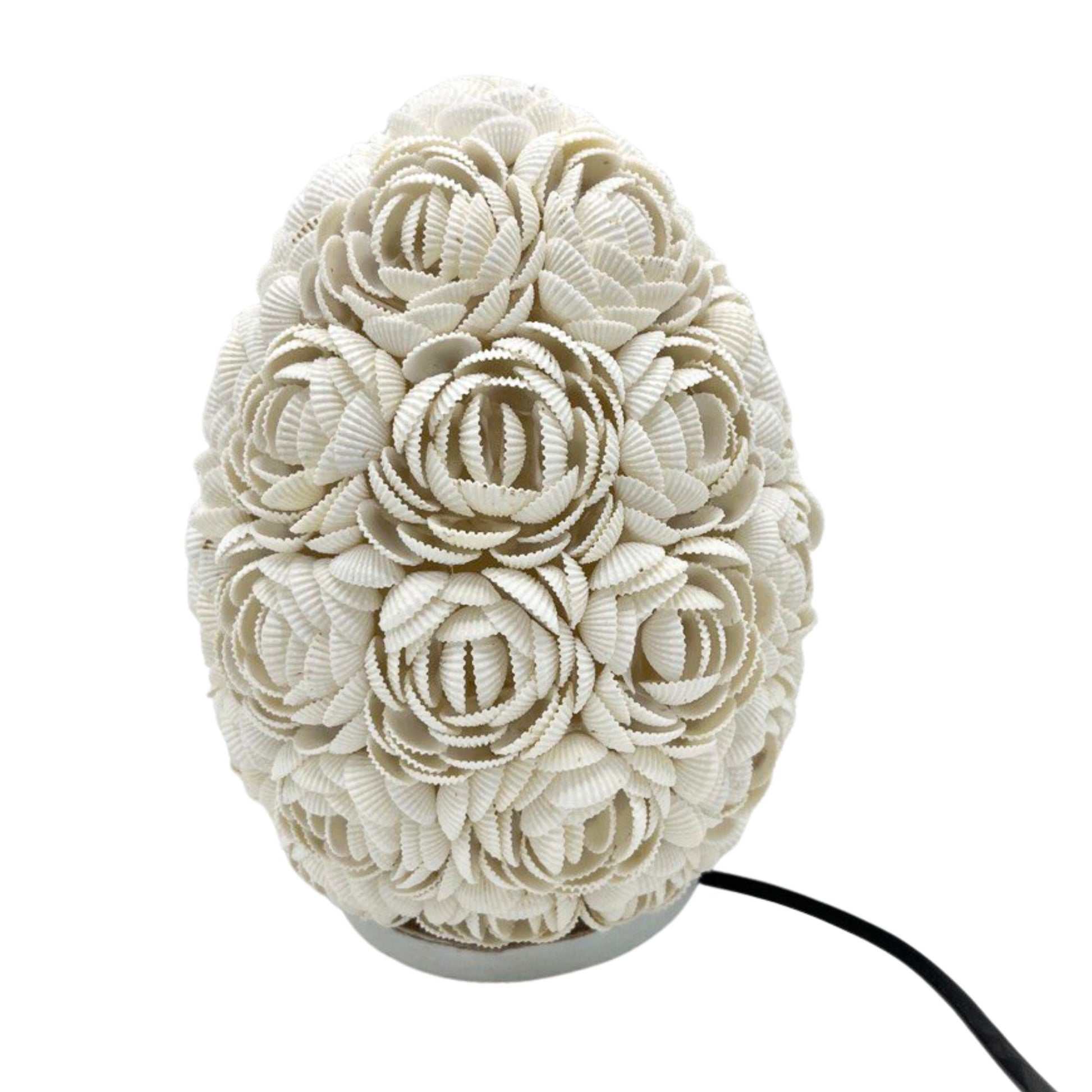 Close-up van roze schelpen lamp met natuurlijke schelpen en warm licht, handgemaakt
