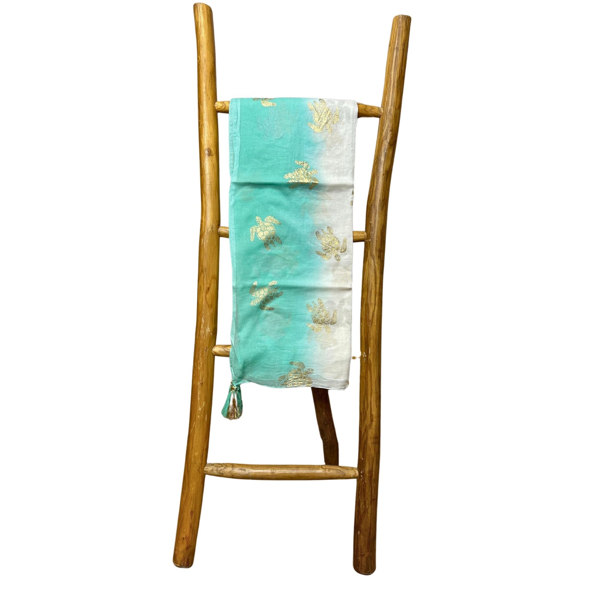 Close-up detail van handbeschilderd turquoise en goud schildpadpatroon op witte sari katoen pario
