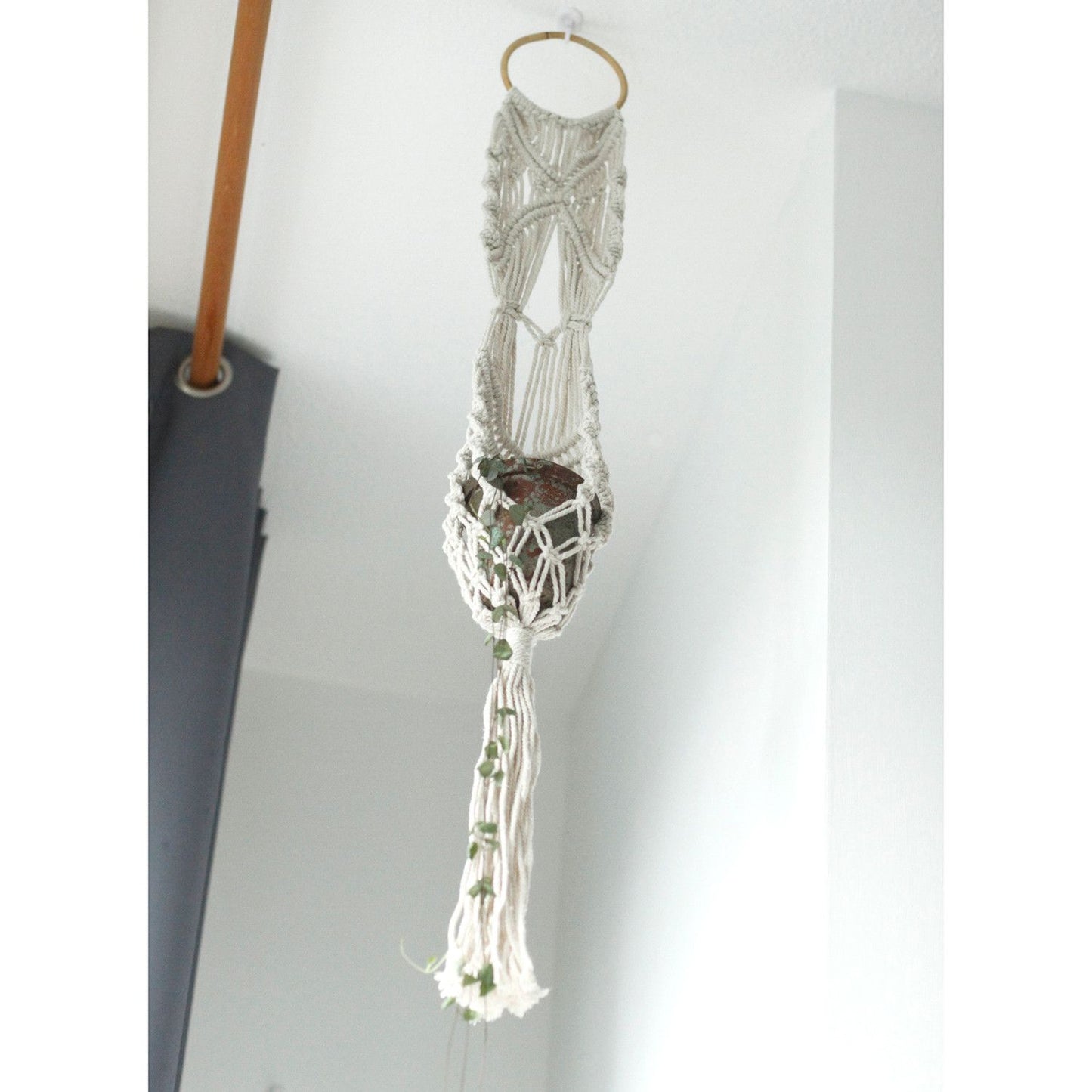 Handgemaakte macramé plantenhouder met natuurlijk katoen en rotan decoratie
